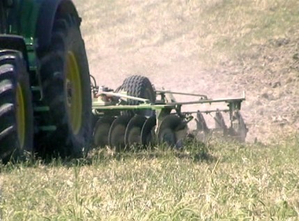 Erpice frangizolle portato dal trattore per preparare il terreno per la semina